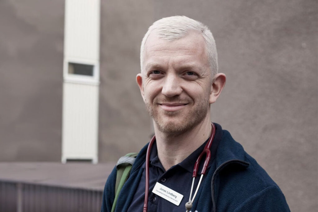 Porträtt av Jonas Lindberg (V), specialistsjuksköterska och sjukvårdspolitisk debattör, bärande arbetskläder och stetoskop